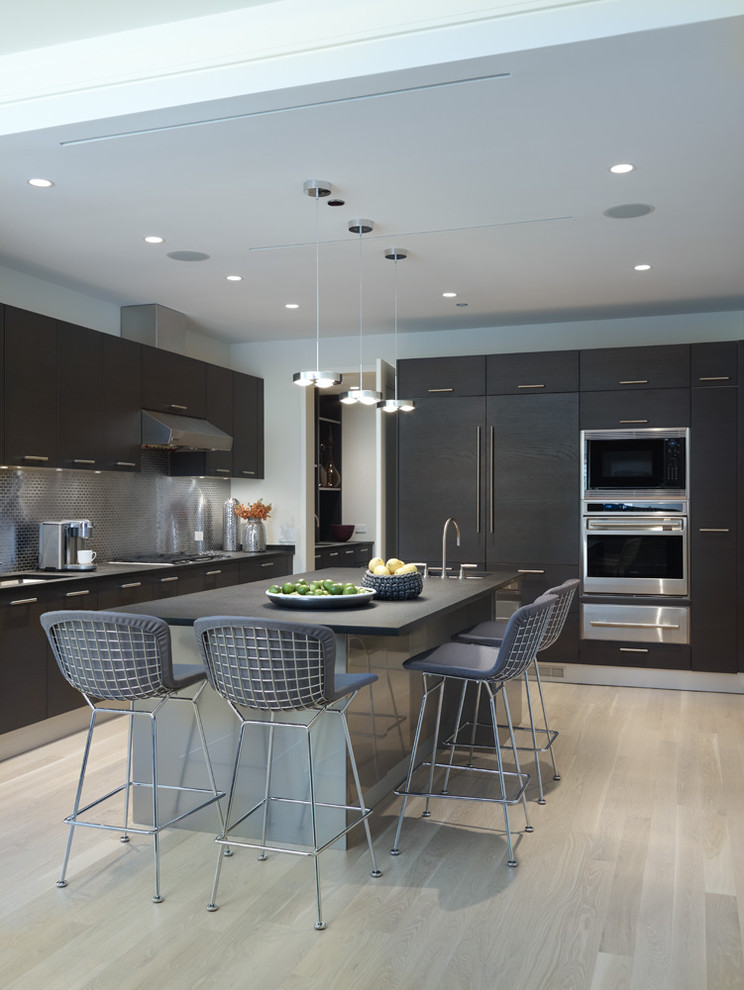 Trendy l-shaped kitchen photo in Other with paneled appliances, flat-panel cabinets, dark wood cabinets, granite countertops, metallic backsplash and metal backsplash