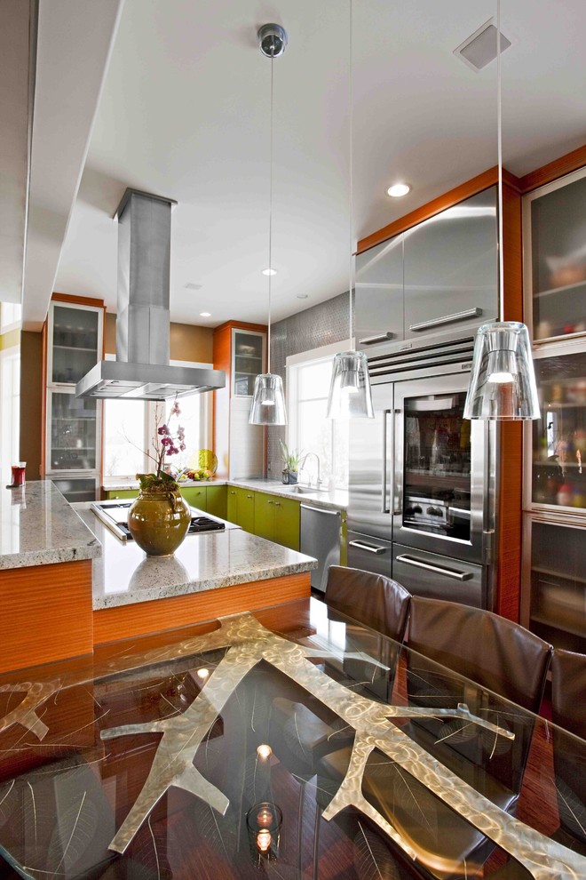 Inspiration for a medium sized contemporary l-shaped open plan kitchen in Salt Lake City with stainless steel appliances, green cabinets, granite worktops, a submerged sink, flat-panel cabinets, metallic splashback, medium hardwood flooring and an island.
