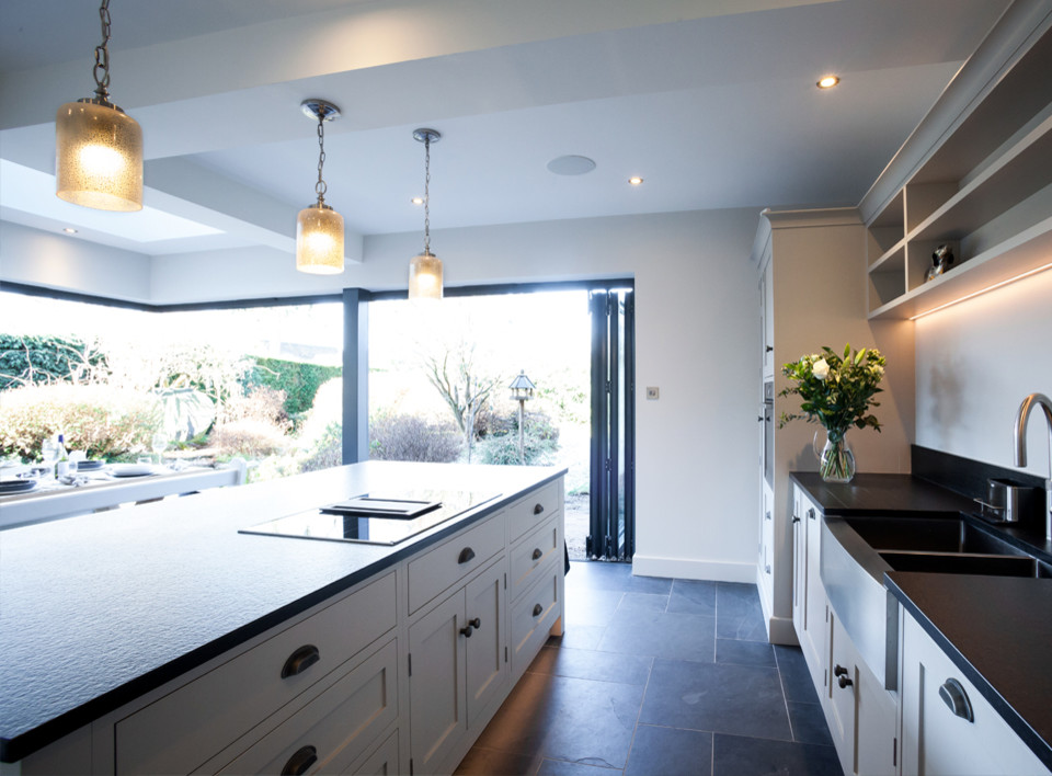 Design ideas for a classic l-shaped kitchen/diner in Other with shaker cabinets, white cabinets, granite worktops, an island and black worktops.