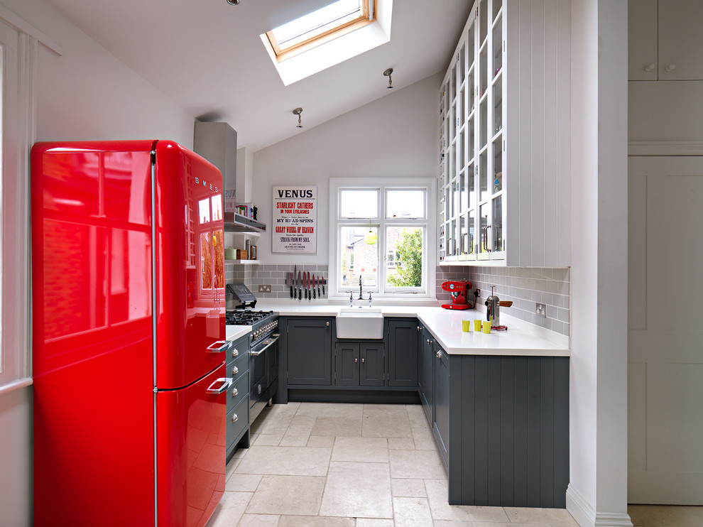 Kitchen - small transitional u-shaped kitchen idea in London with a farmhouse sink, shaker cabinets, gray cabinets, gray backsplash, subway tile backsplash and no island
