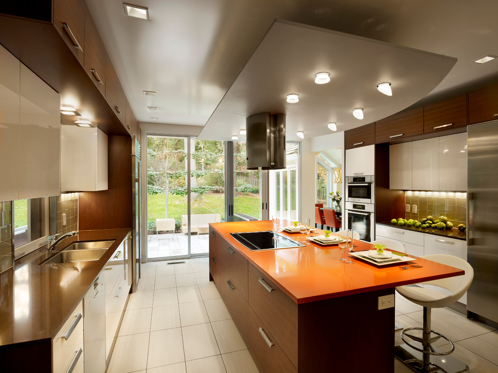 Large trendy galley porcelain tile eat-in kitchen photo in Philadelphia with a double-bowl sink, flat-panel cabinets, white cabinets, quartz countertops, beige backsplash, glass tile backsplash, stainless steel appliances, an island and orange countertops