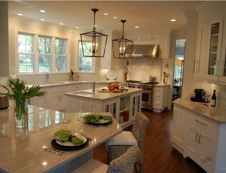 Imagen de cocina contemporánea con puertas de armario blancas, salpicadero blanco, electrodomésticos de acero inoxidable, suelo de madera en tonos medios y dos o más islas