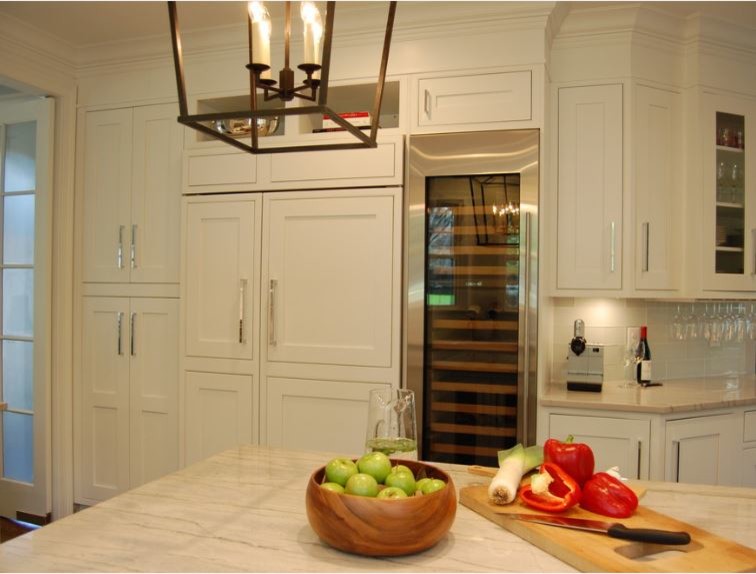Moderne Küche mit weißen Schränken, Küchenrückwand in Weiß, Küchengeräten aus Edelstahl, braunem Holzboden und zwei Kücheninseln in Sonstige
