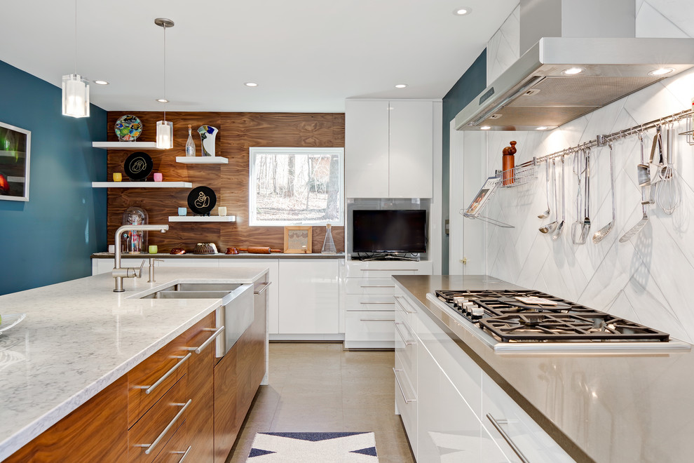 Example of a mid-sized trendy l-shaped cork floor and beige floor enclosed kitchen design in Other with a farmhouse sink, flat-panel cabinets, white cabinets, quartz countertops, white backsplash, stone tile backsplash, stainless steel appliances and an island