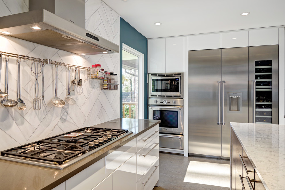 Example of a mid-sized trendy l-shaped cork floor and beige floor enclosed kitchen design in Other with a farmhouse sink, flat-panel cabinets, white cabinets, quartz countertops, white backsplash, stainless steel appliances, an island and stone tile backsplash