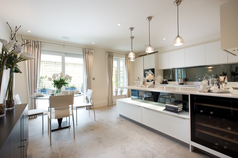 Example of a mid-sized trendy u-shaped open concept kitchen design in Berkshire with a drop-in sink, flat-panel cabinets, white cabinets, quartzite countertops, gray backsplash, mirror backsplash, paneled appliances and an island
