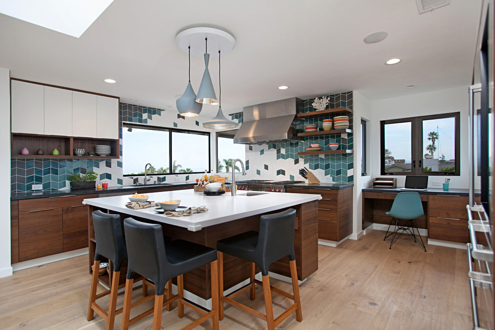 This is an example of a contemporary u-shaped enclosed kitchen in San Diego with a submerged sink, flat-panel cabinets, dark wood cabinets, multi-coloured splashback, stainless steel appliances, light hardwood flooring, an island and beige floors.