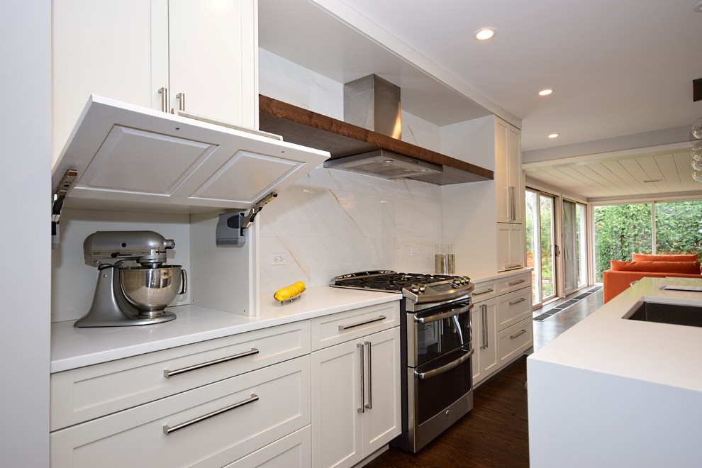 Exempel på ett litet modernt linjärt kök och matrum, med en undermonterad diskho, luckor med infälld panel, vita skåp, bänkskiva i kvarts, vitt stänkskydd, stänkskydd i porslinskakel, rostfria vitvaror, mellanmörkt trägolv och en köksö
