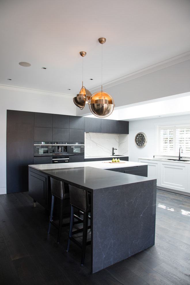 Inspiration for an expansive contemporary l-shaped kitchen in Sydney with a double-bowl sink, black cabinets, engineered stone countertops, white splashback, stone slab splashback, black appliances, dark hardwood flooring, black floors, white worktops, flat-panel cabinets and an island.