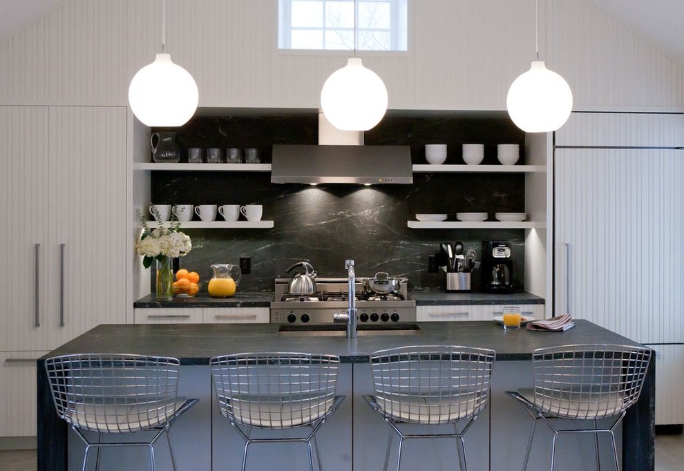 Kitchen - contemporary galley kitchen idea in Boston with a single-bowl sink, white cabinets, black backsplash, paneled appliances, flat-panel cabinets and stone slab backsplash