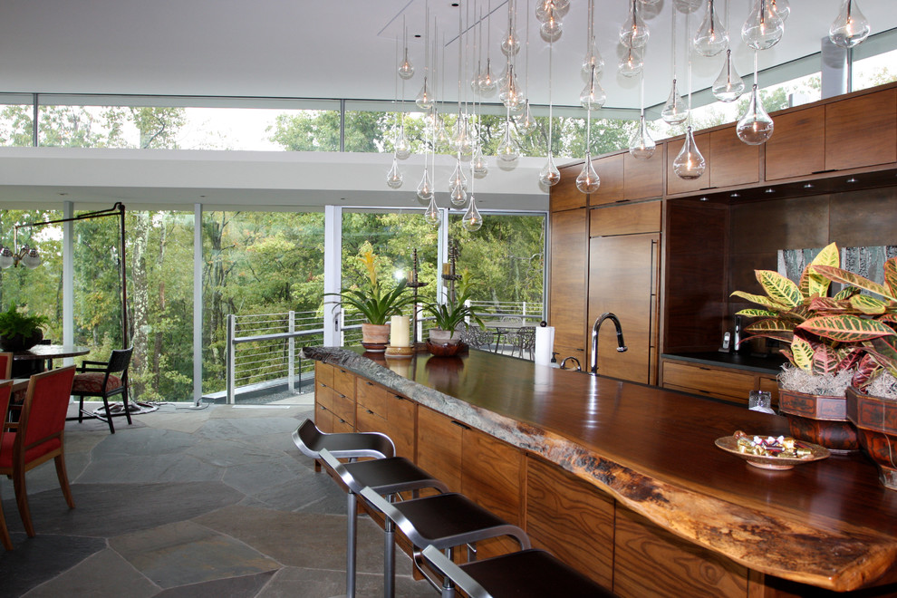 Moderne Wohnküche mit flächenbündigen Schrankfronten, hellbraunen Holzschränken und Arbeitsplatte aus Holz in Sonstige