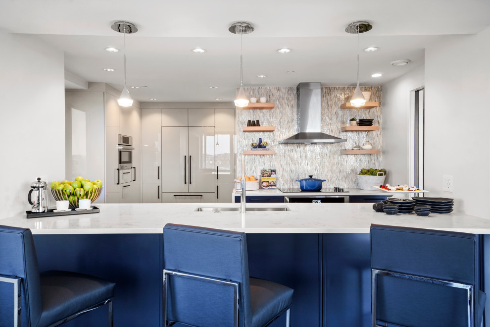 Foto di una cucina minimal di medie dimensioni con lavello sottopiano, ante in stile shaker, ante blu, top in quarzo composito, paraspruzzi blu, paraspruzzi con piastrelle di vetro, elettrodomestici da incasso, parquet scuro, pavimento marrone e top bianco