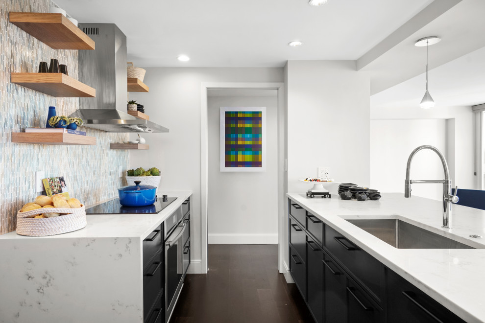 ボストンにある高級な中くらいなコンテンポラリースタイルのおしゃれなキッチン (アンダーカウンターシンク、シェーカースタイル扉のキャビネット、青いキャビネット、クオーツストーンカウンター、青いキッチンパネル、ガラスタイルのキッチンパネル、パネルと同色の調理設備、濃色無垢フローリング、茶色い床、白いキッチンカウンター) の写真