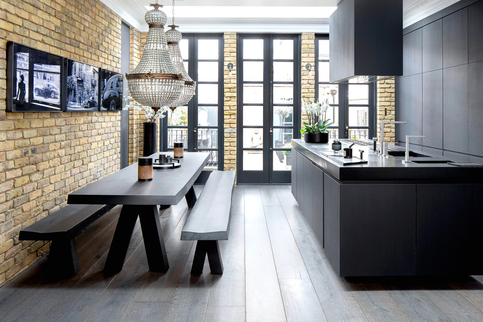 Mittelgroße Moderne Wohnküche mit flächenbündigen Schrankfronten, schwarzen Schränken, Mineralwerkstoff-Arbeitsplatte, dunklem Holzboden, Kücheninsel, braunem Boden und Doppelwaschbecken in London
