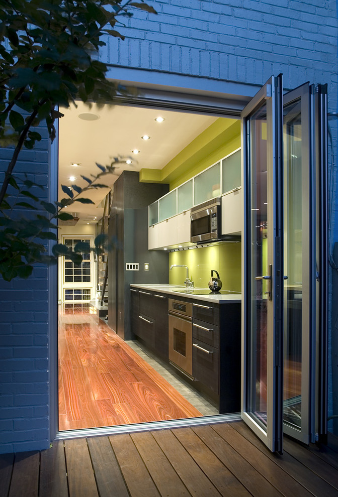 Idées déco pour une cuisine linéaire contemporaine avec un placard à porte plane, des portes de placard noires et un électroménager en acier inoxydable.