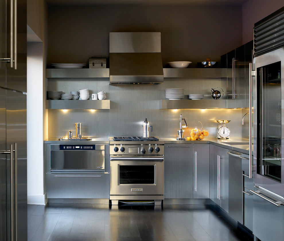 Bild på ett funkis kök, med rostfria vitvaror, bänkskiva i rostfritt stål, släta luckor, skåp i rostfritt stål, stänkskydd med metallisk yta och stänkskydd i metallkakel