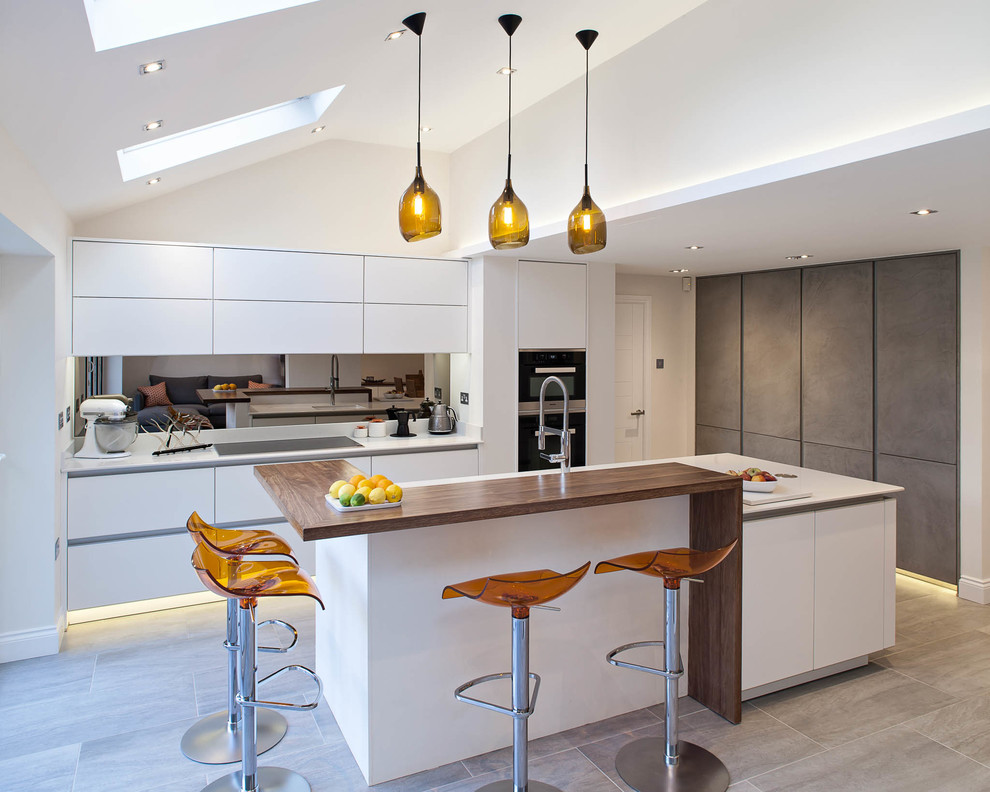 Example of a large trendy kitchen design in Hertfordshire with flat-panel cabinets, white cabinets, metallic backsplash, mirror backsplash and an island
