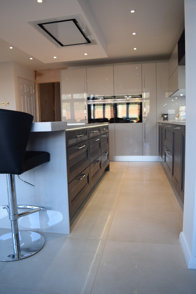 Contemporary kitchen in Hampshire with grey cabinets, quartz worktops, an island and white worktops.