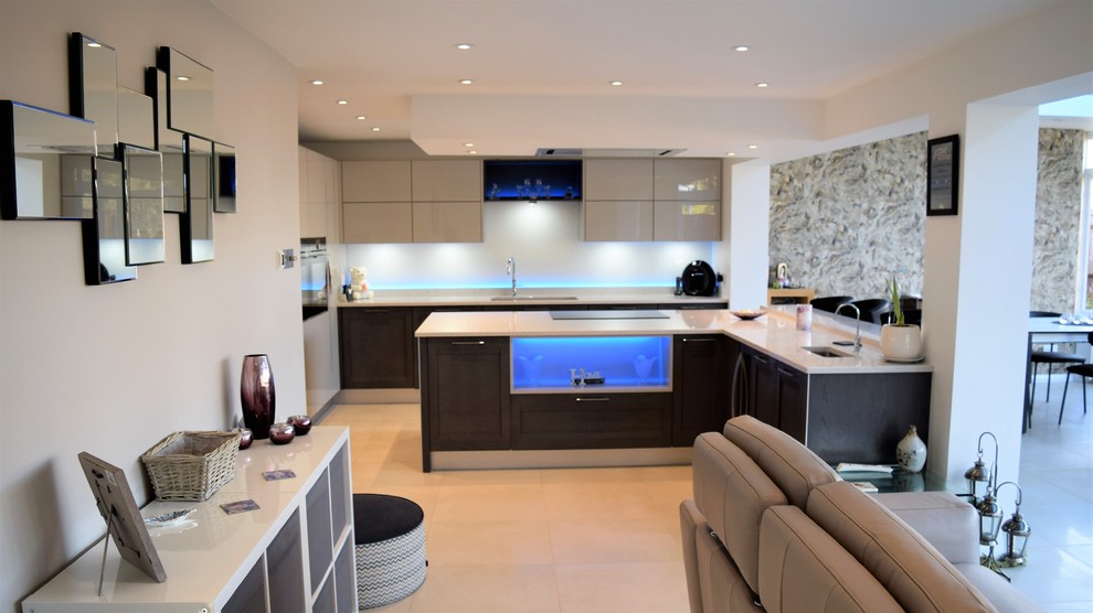 На фото: кухня в современном стиле с серыми фасадами, столешницей из кварцита, островом и белой столешницей с