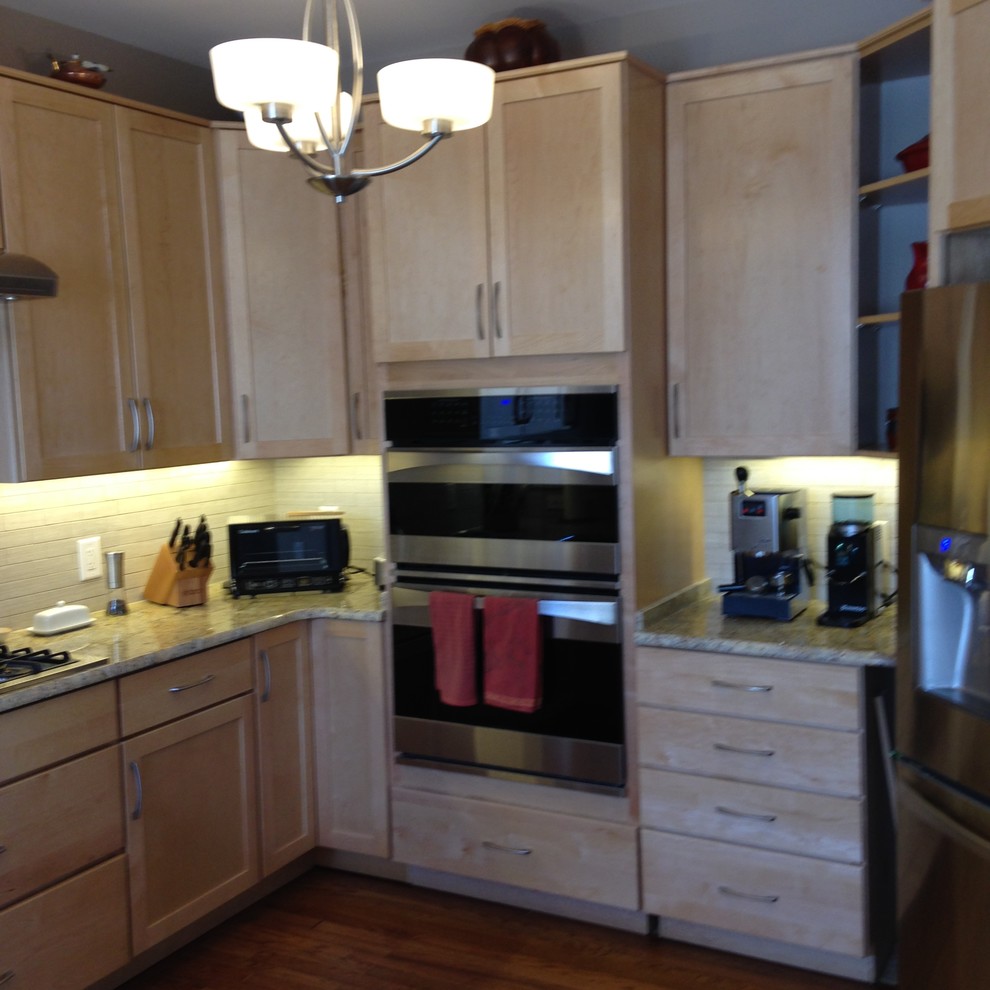 Foto på ett stort funkis kök, med en dubbel diskho, skåp i shakerstil, skåp i ljust trä, granitbänkskiva, flerfärgad stänkskydd, stänkskydd i porslinskakel, rostfria vitvaror, mellanmörkt trägolv och en halv köksö