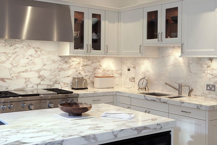 Esempio di una cucina minimal di medie dimensioni con lavello sottopiano, ante a filo, ante bianche, top in marmo, paraspruzzi in lastra di pietra e elettrodomestici in acciaio inossidabile