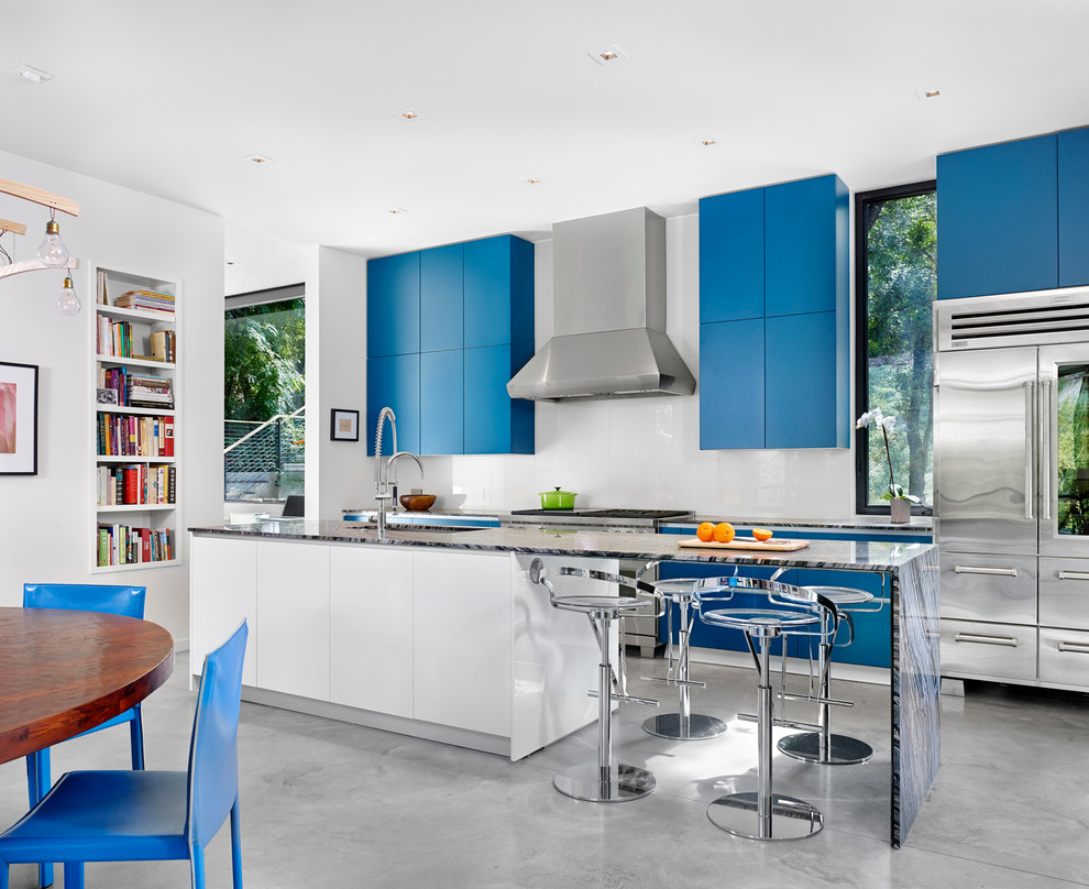 Inspiration för moderna kök, med en undermonterad diskho, släta luckor, blå skåp, vitt stänkskydd, glaspanel som stänkskydd, rostfria vitvaror, betonggolv och en köksö