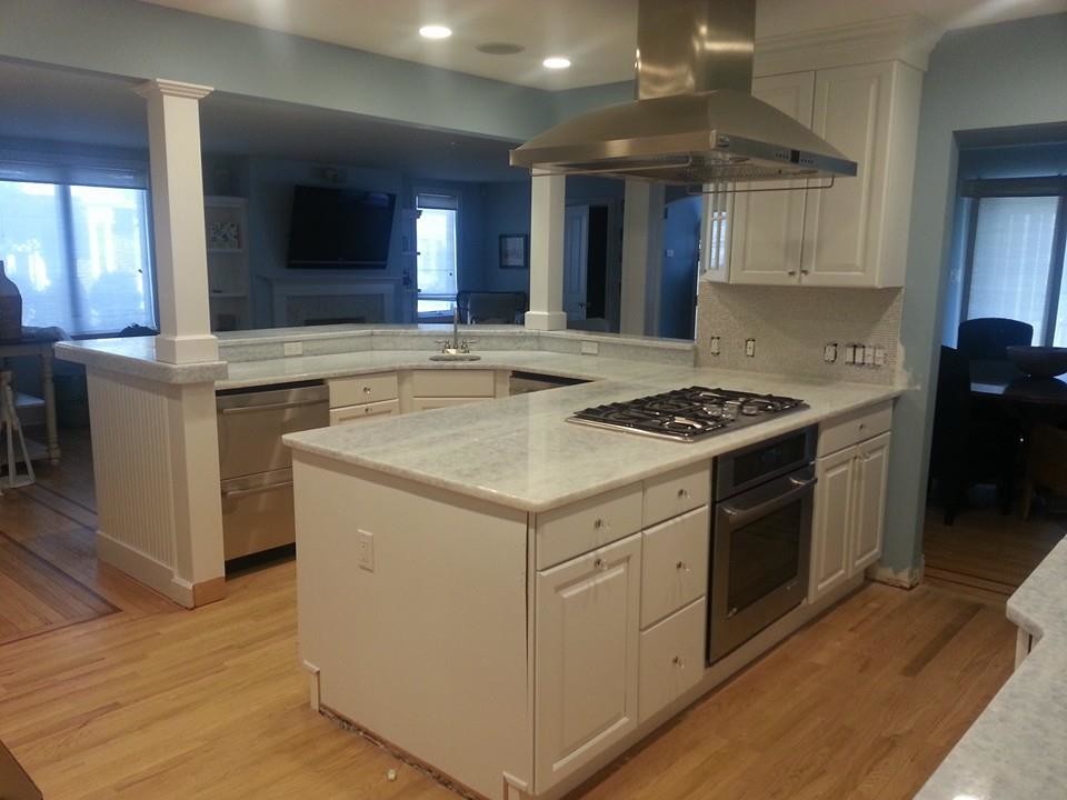 Idéer för att renovera ett avskilt, mellanstort funkis u-kök, med en undermonterad diskho, luckor med upphöjd panel, vita skåp, marmorbänkskiva, grått stänkskydd, stänkskydd i sten, rostfria vitvaror, ljust trägolv och en halv köksö