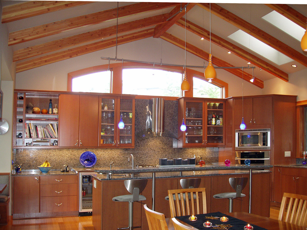 シアトルにある高級な広いコンテンポラリースタイルのおしゃれなキッチン (アンダーカウンターシンク、フラットパネル扉のキャビネット、中間色木目調キャビネット、御影石カウンター、石スラブのキッチンパネル、シルバーの調理設備、竹フローリング) の写真