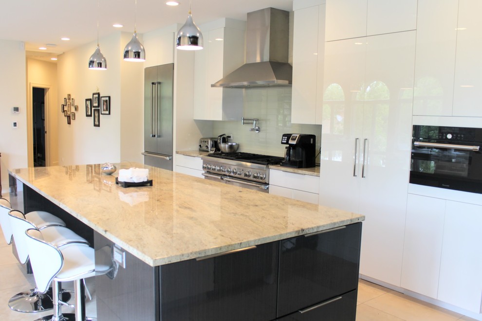 Inspiration for a medium sized contemporary u-shaped kitchen/diner in Chicago with a submerged sink, white cabinets, white splashback, metro tiled splashback, stainless steel appliances, porcelain flooring, an island, beige floors, multicoloured worktops, flat-panel cabinets and granite worktops.