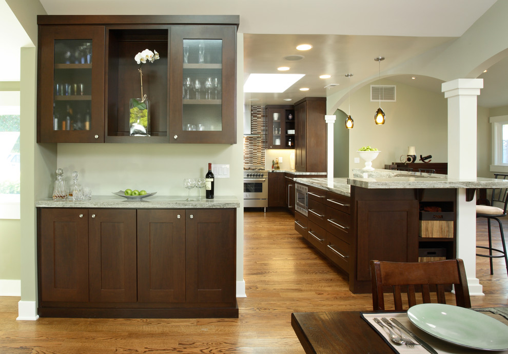Cette photo montre une cuisine américaine tendance en bois foncé avec un placard à porte shaker et un électroménager en acier inoxydable.