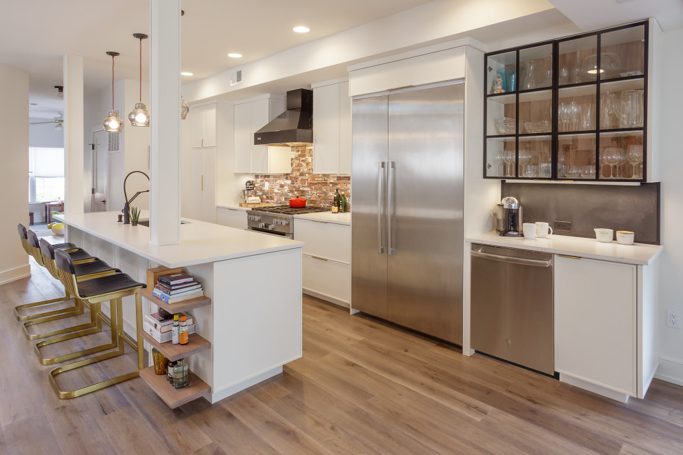 This is an example of a small contemporary single-wall kitchen/diner in New York with a submerged sink, flat-panel cabinets, white cabinets, engineered stone countertops, brick splashback, stainless steel appliances, light hardwood flooring, an island and white worktops.