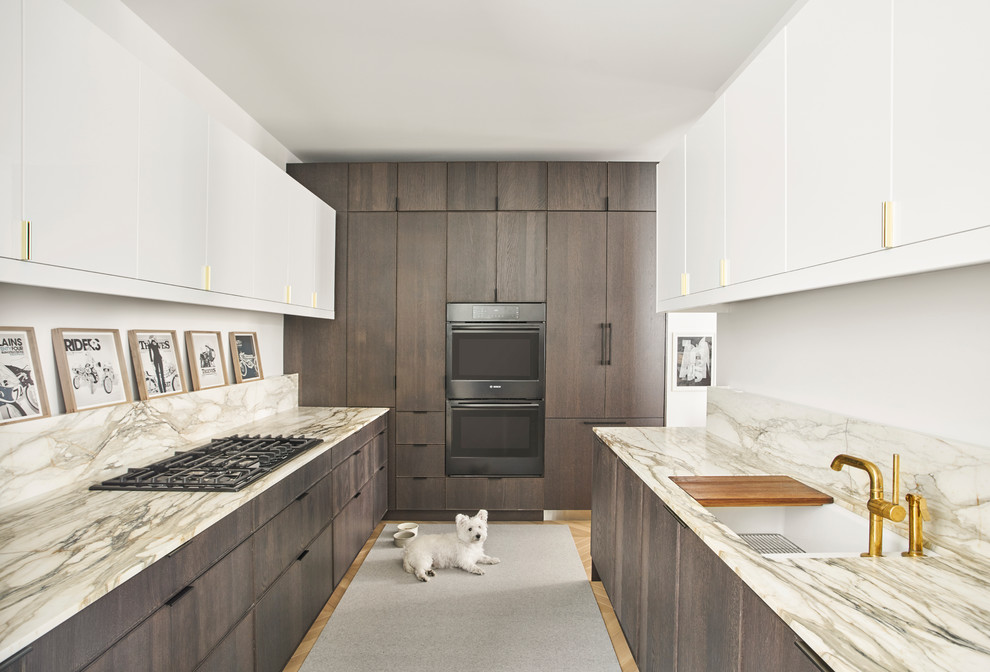 Foto di una cucina ad U minimal con lavello sottopiano, ante lisce, ante in legno bruno, elettrodomestici neri e nessuna isola