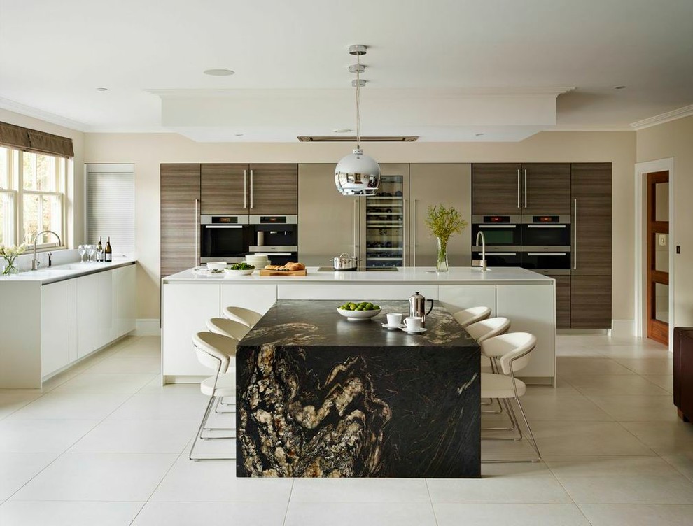 Bild på ett stort funkis kök och matrum, med släta luckor, vita skåp, en köksö och integrerade vitvaror