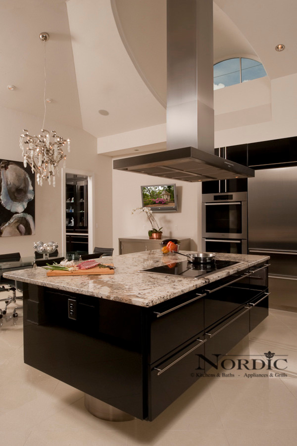 Inspiration for a large contemporary u-shaped porcelain tile eat-in kitchen remodel in New Orleans with an undermount sink, flat-panel cabinets, black cabinets, granite countertops, stainless steel appliances, black backsplash, glass sheet backsplash and an island