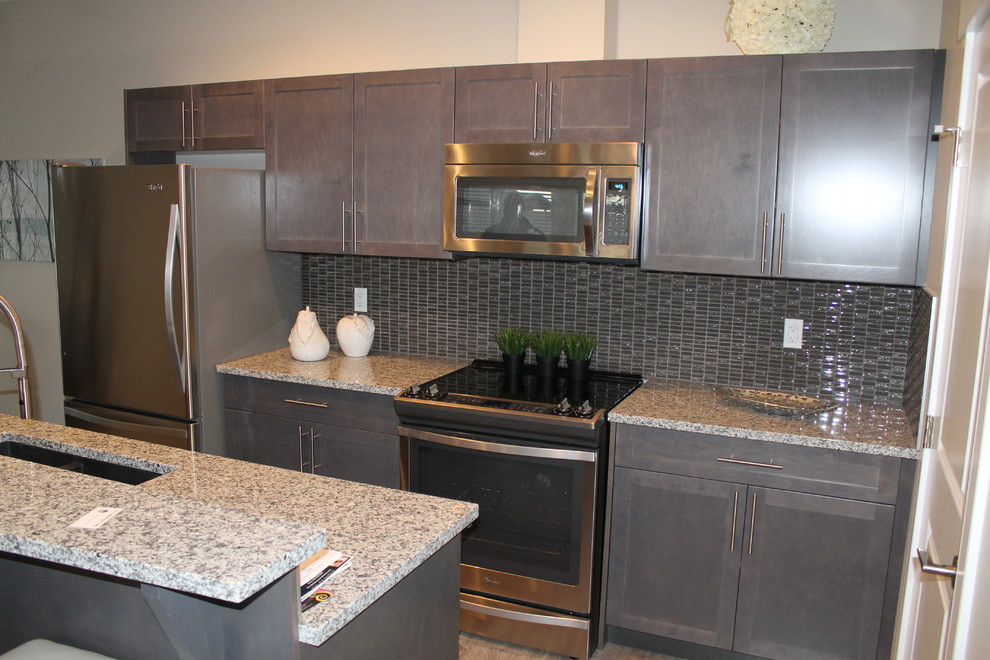Exempel på ett mellanstort modernt kök, med en undermonterad diskho, skåp i shakerstil, grå skåp, granitbänkskiva, grått stänkskydd, stänkskydd i glaskakel, rostfria vitvaror, en köksö, klinkergolv i porslin och grått golv