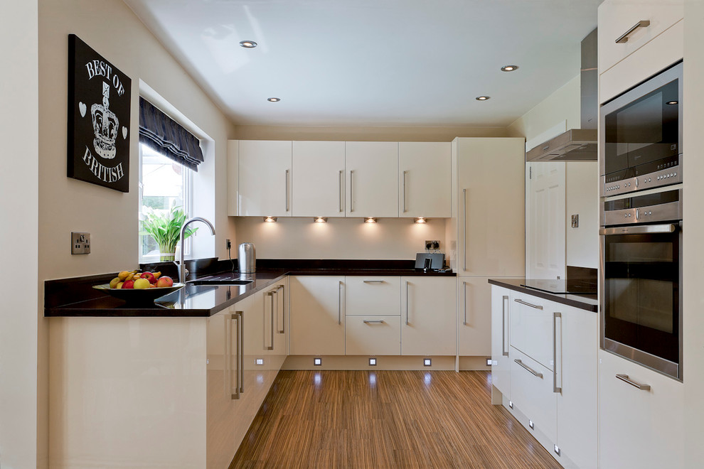 Small trendy u-shaped bamboo floor kitchen photo in Other