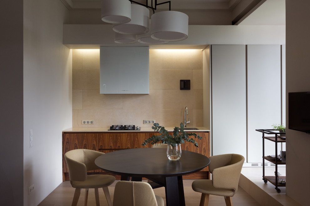 Photo of a contemporary single-wall kitchen/diner in Dorset with a built-in sink, flat-panel cabinets, medium wood cabinets, beige splashback, no island, brown floors and beige worktops.