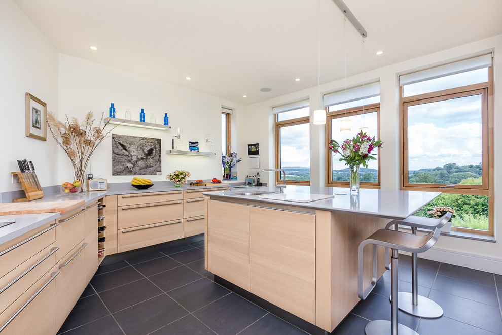 Moderne Küche mit Unterbauwaschbecken, flächenbündigen Schrankfronten, hellen Holzschränken und Kücheninsel in Surrey