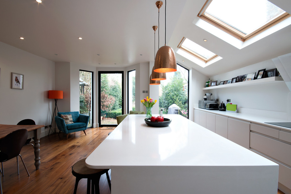Esempio di una cucina design con ante lisce, ante bianche e pavimento in legno massello medio