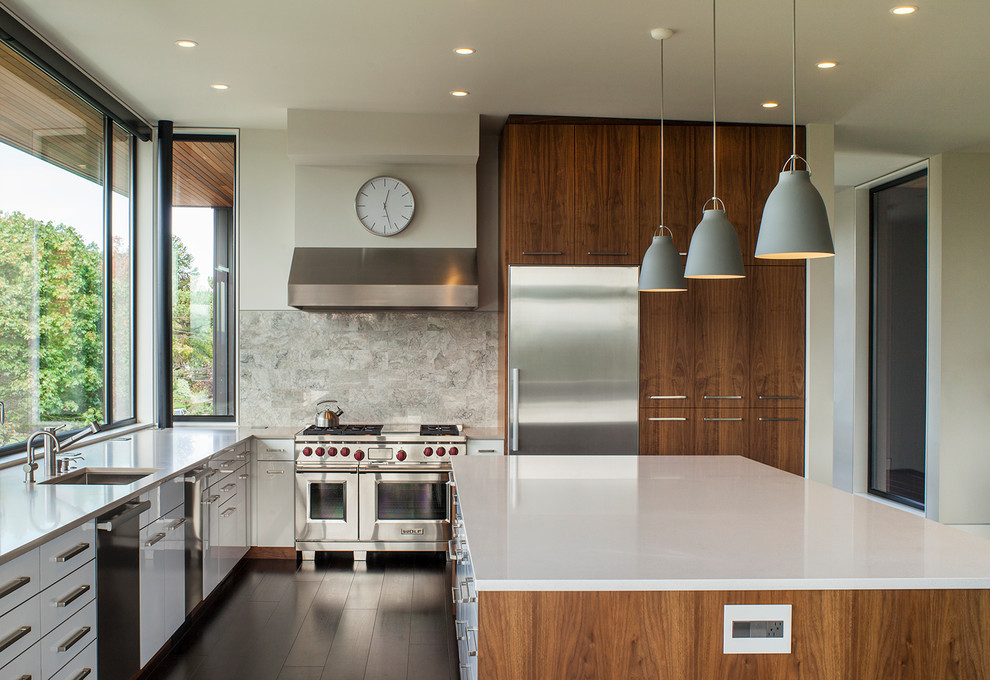 Moderne Küche in L-Form mit Küchengeräten aus Edelstahl, Kücheninsel, Küchenrückwand in Grau und Rückwand aus Steinfliesen in Portland