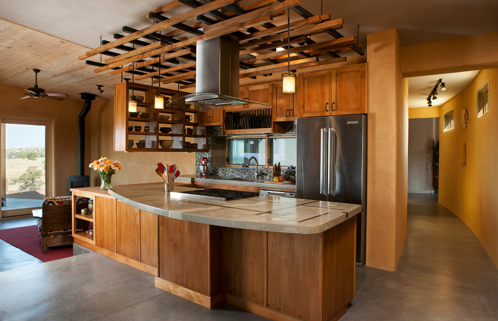 Idée de décoration pour une cuisine ouverte parallèle sud-ouest américain en bois brun avec un électroménager en acier inoxydable et un plan de travail en béton.