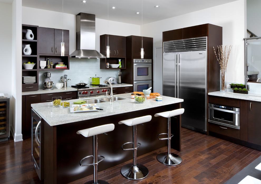Moderne Küche in L-Form mit Doppelwaschbecken, flächenbündigen Schrankfronten, dunklen Holzschränken, Küchenrückwand in Blau, Küchengeräten aus Edelstahl und dunklem Holzboden in Toronto