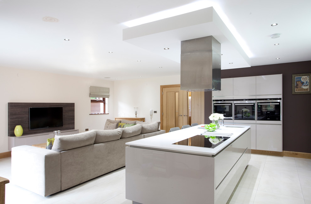 Идея дизайна: кухня-гостиная в современном стиле с врезной мойкой, плоскими фасадами и белыми фасадами