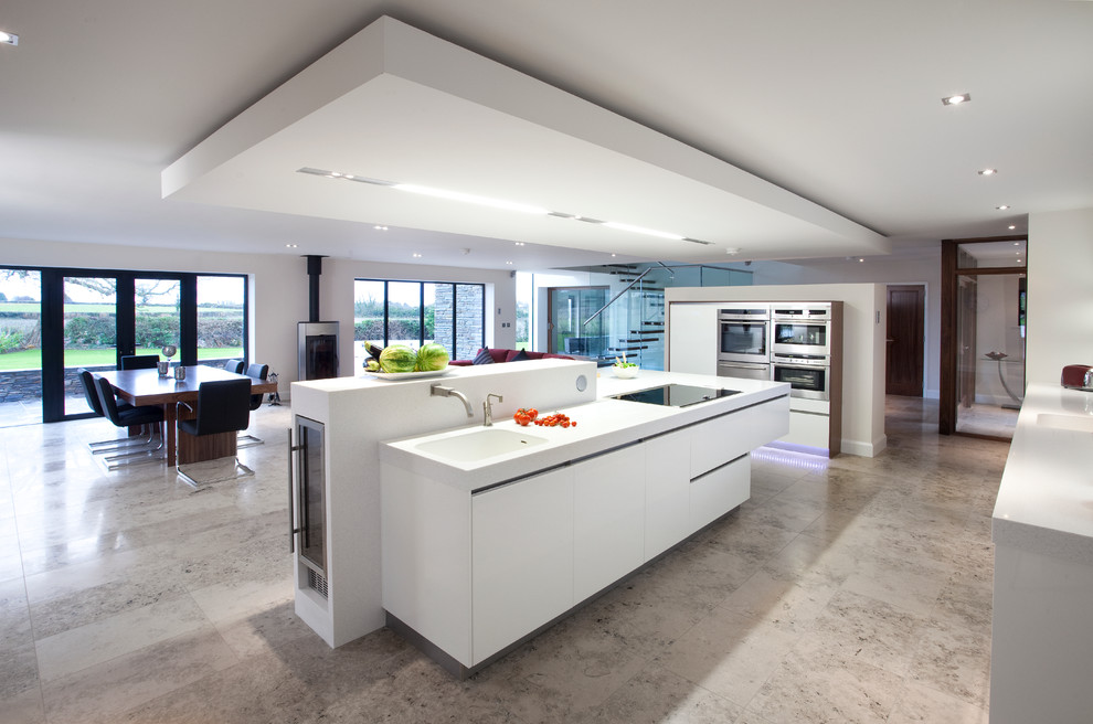Photo of a large contemporary kitchen/diner in Belfast with a built-in sink, flat-panel cabinets and white cabinets.