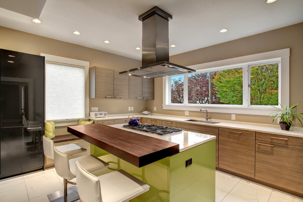 Moderne Küche mit Unterbauwaschbecken, flächenbündigen Schrankfronten, hellbraunen Holzschränken, schwarzen Elektrogeräten und Kücheninsel in Seattle