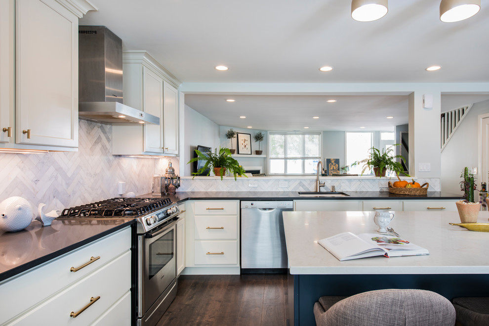 Large trendy l-shaped brown floor and medium tone wood floor eat-in kitchen photo in Philadelphia with an undermount sink, white cabinets, quartz countertops, gray backsplash, marble backsplash, stainless steel appliances, an island and shaker cabinets