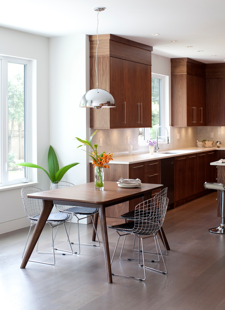Aménagement d'une cuisine américaine contemporaine en bois brun avec un placard à porte plane, une crédence blanche et un électroménager en acier inoxydable.