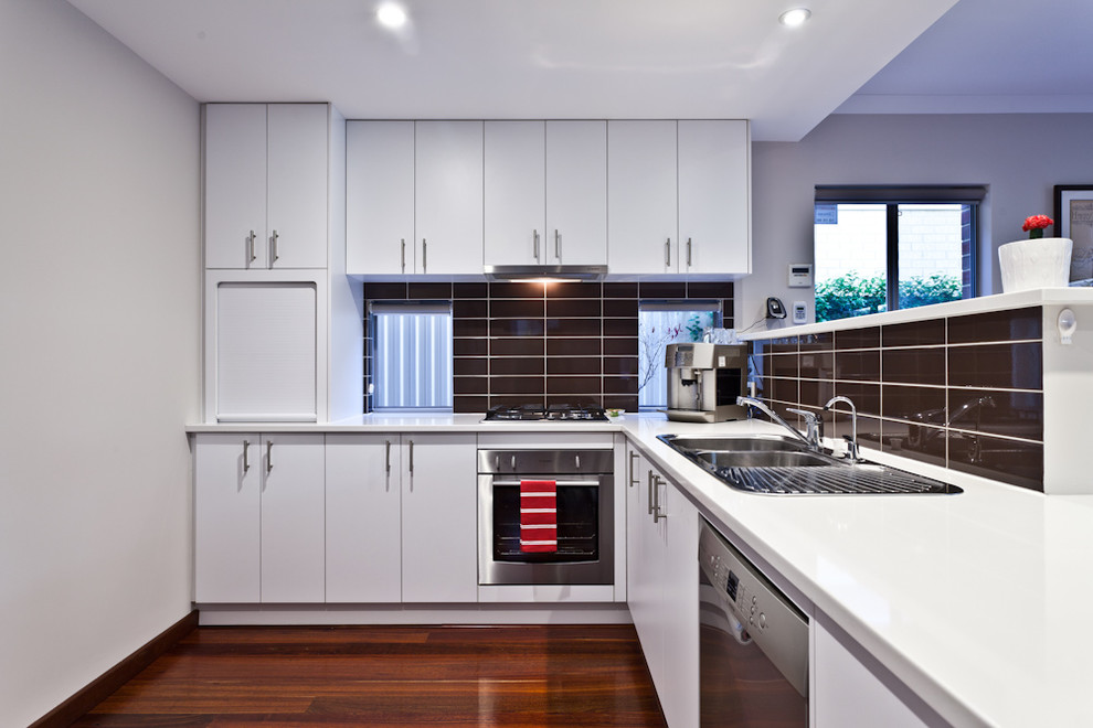 Moderne Küche mit Einbauwaschbecken, flächenbündigen Schrankfronten, weißen Schränken, Küchenrückwand in Braun, Rückwand aus Metrofliesen und Küchengeräten aus Edelstahl in Perth