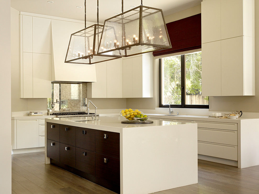 На фото: кухня в современном стиле с плоскими фасадами, белыми фасадами и фартуком из стекла