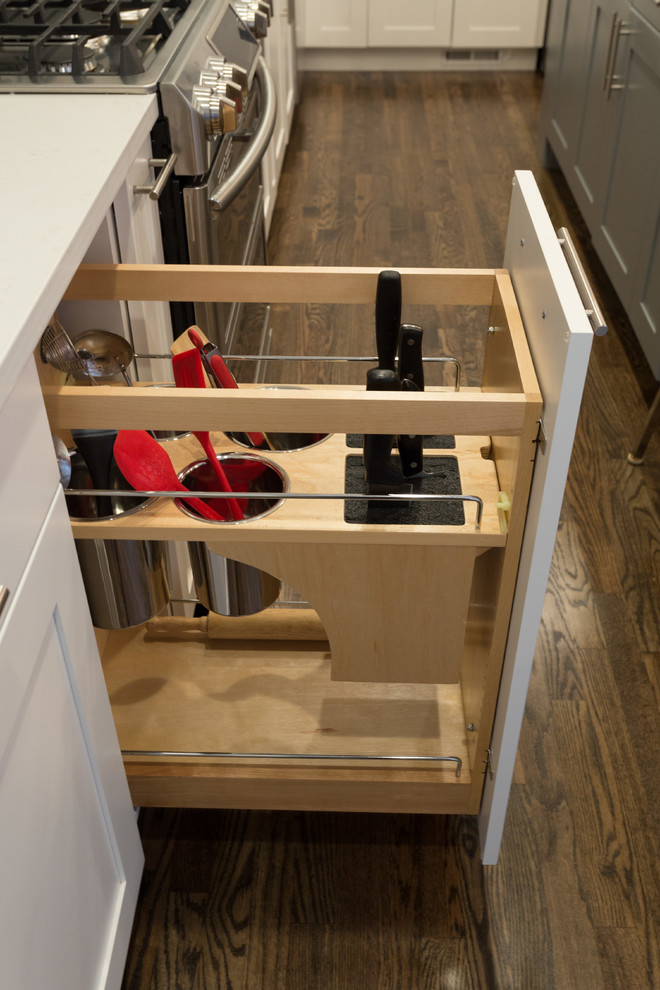 Example of a mid-sized urban l-shaped dark wood floor open concept kitchen design in Chicago with an undermount sink, shaker cabinets, white cabinets, quartz countertops, multicolored backsplash, subway tile backsplash, stainless steel appliances and an island